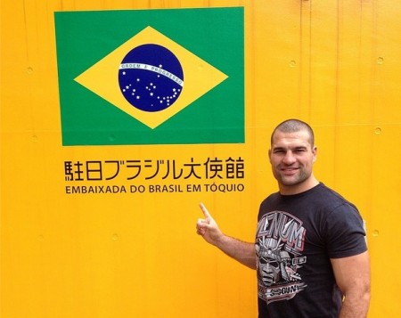 M. Shogun posa ao lado da bandeira brasileira na embaixada em Tóquio. Foto: Reprodução/Instagram