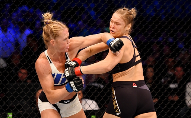 Holm (esq.) foi implacável contra Ronda (dir.) em Melbourne. Foto: Josh Hedges/UFC